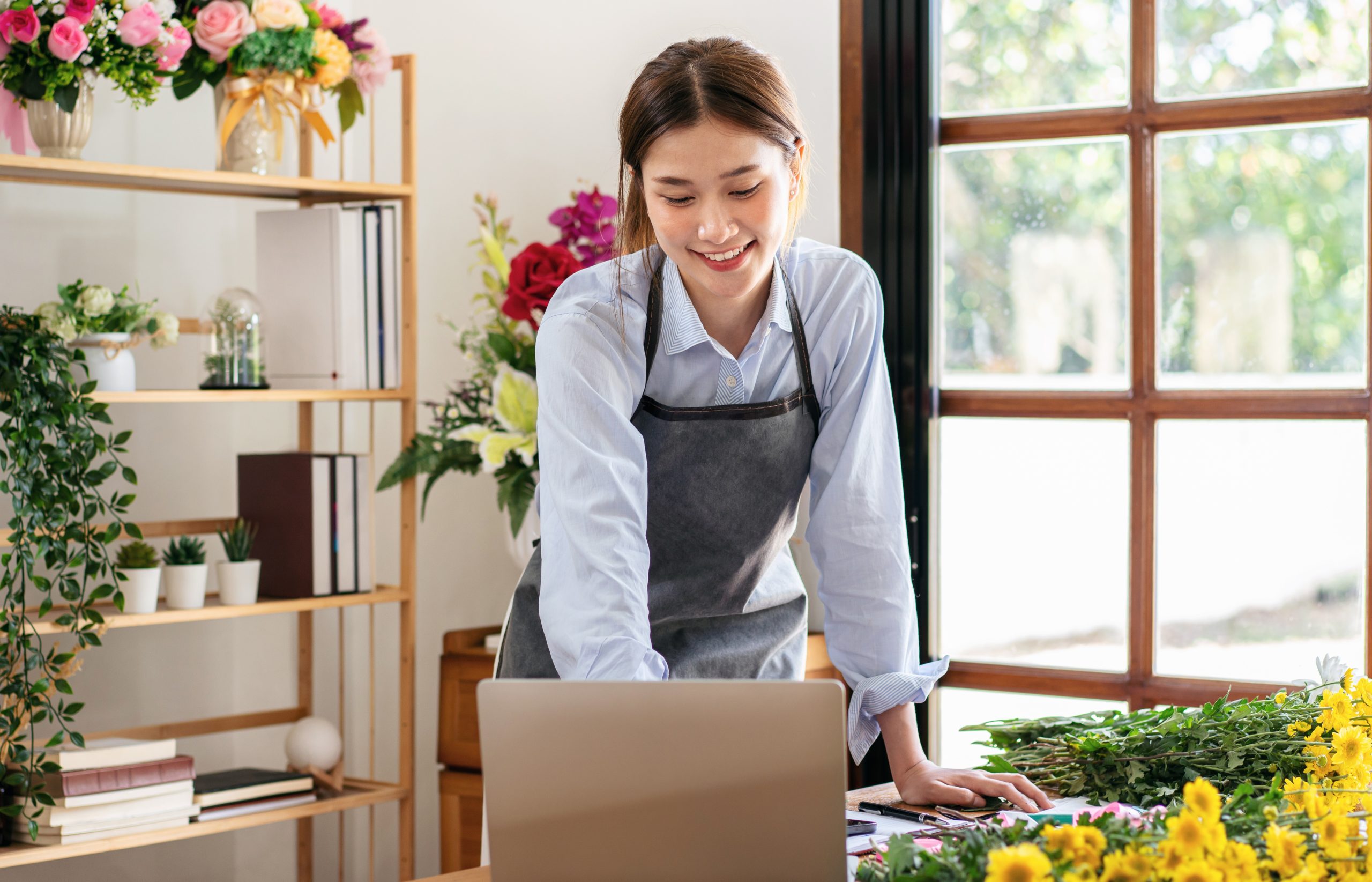 florist-in-apron-using-laptop-to-working